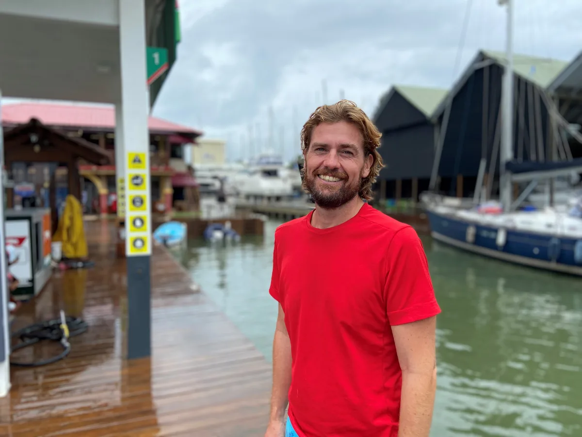 Nicolai Christiansen in rotem T-Shirt an einem Segelhafen